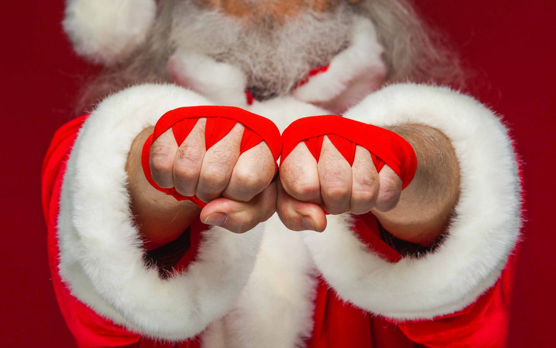 A close-up of Santa Claus wearing red martial arts hand wraps, holding his fists out as a creative holiday gift guide idea for fighters.